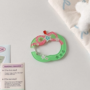 Detail of apple-shaped acrylic keychain with pink bow and silver metal clasp