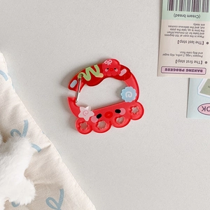 Macro view of red translucent acrylic carabiner with cute octopus and star charms