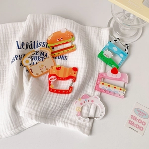 Close-up of assorted acrylic backpack charms featuring food and animal shapes with D-rings