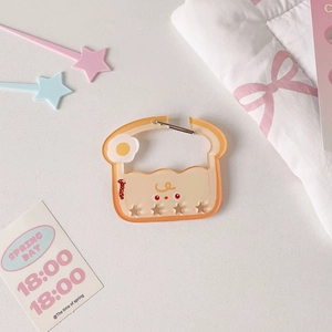 Macro shot of cute toasted bread acrylic keychain with smiling egg pattern and metal clasp