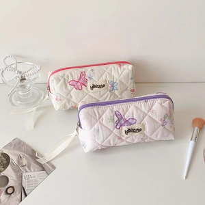 Quilted butterfly cosmetic bags with top handles and branded label in soft pastel colors
