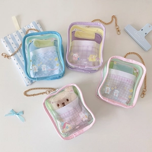 Close-up of transparent PVC plush display bag with mini bedding and gold metal chain