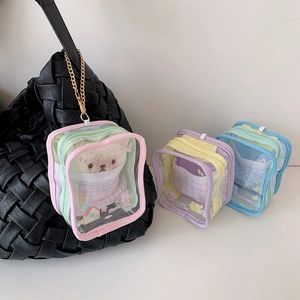 Detailed view of clear PVC doll display bag with cartoon prints on a black tote