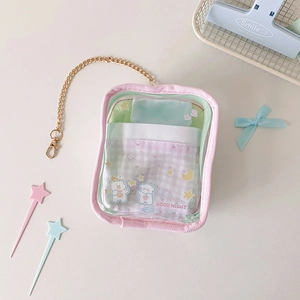 Pink border transparent pouch with miniature bed scene and golden chain detail view