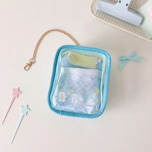 Close-up of light blue transparent PVC doll bag with plush bear bedding and gold chain
