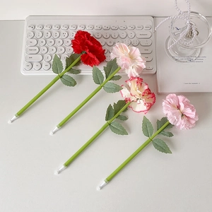 Creative carnation flower ballpoint pens in four colors on an aesthetic desk setup