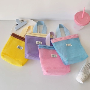 Detail view of colorful macaron mesh organizer bags in pink, blue, yellow, and purple