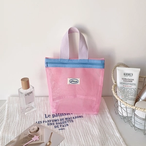 Pink mesh storage bag with purple handles and blue zipper for toiletries and cosmetics