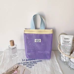Detail of purple mesh storage bag featuring light blue handle and contrast yellow zipper