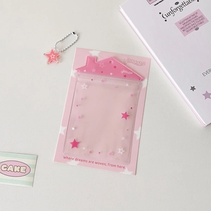 Détail du porte-cartes transparent en PVC rose en forme de maison avec des motifs d'étoiles