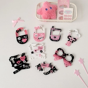 Close-up of sweet and gothic acrylic charms with skulls and hearts for bag decoration
