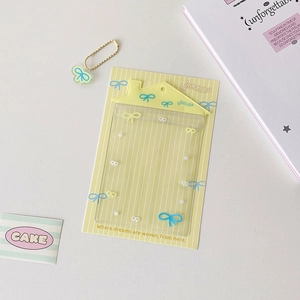 Gros plan du porte-carte en PVC transparent avec haut en maison jaune et nœuds mignons