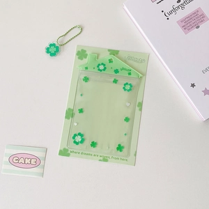 Détail d'un porte-carte en forme de maison avec trèfle à quatre feuilles et pendentif assorti