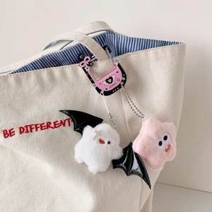 Plush ghost and star bag charms with a star-shaped metal carabiner on a canvas tote