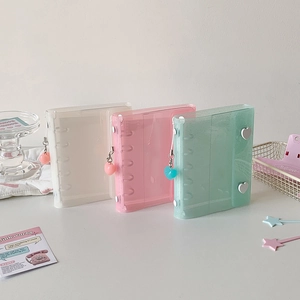 Detail view of transparent mini photo albums in pink, white, and green with heart charms