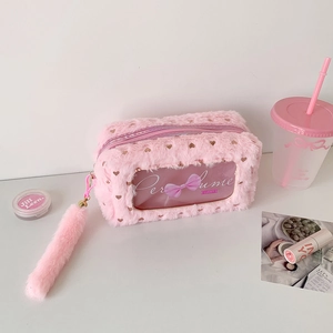 Detail of pink plush pouch with gold heart sequins, clear window and fluffy tail charm