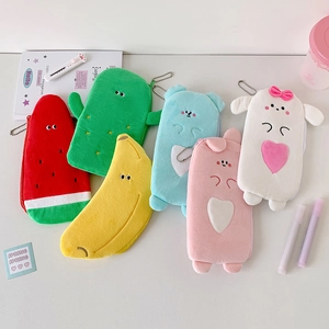 Detail of plush cartoon fruit pouches with zipper and bead chain on white desk