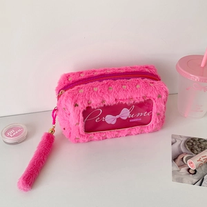 Detail of plush makeup bag with transparent window, metal zipper and fuzzy pom pom
