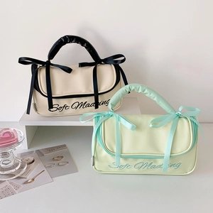 Detail of minimalist PU storage bags with ribbon bows and soft pleated handles