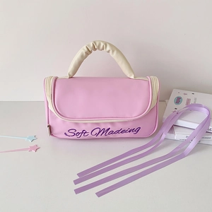 Detailed view of pink leather makeup bag with pleated handle and ribbon decoration