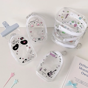 Detail of transparent PVC mini storage pouches with cartoon prints and metal hooks