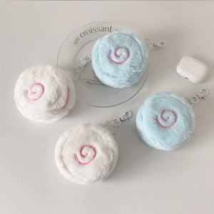 Macro detail of plush macaron coin purses with pink spiral embroidery and metal hooks
