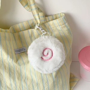 Detail of round plush coin purse with pink spiral embroidery and white hook on a bag