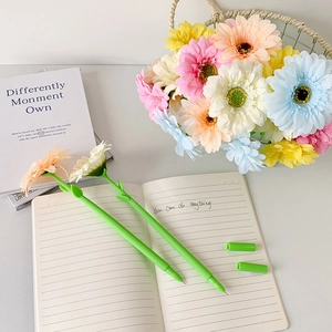 Detail of two creative daisy pens in pink and white colors on a notebook