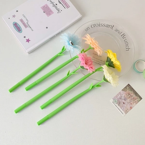 Flat lay of colorful flower-shaped ballpoint pens with green stems on a white desk