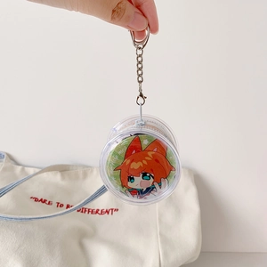 Close-up of a clear PVC round badge holder with a metal chain for anime charms
