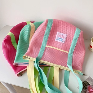 Detalle de bolsas de playa de malla con asas de colores y cierre de cremallera