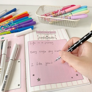 Set of 6 colorful 0.5mm cartoon gel pens for journaling on a pink notebook