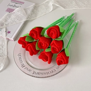 Realistic red rose ballpoint pens set in a glass plate with decorative lace ribbon