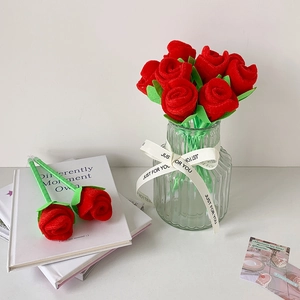 Detail of red plush rose pens in a glass vase on books for home office decor