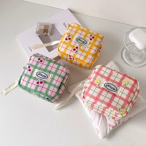 Detailed close-up of square canvas pouches with cherry prints and zip closure