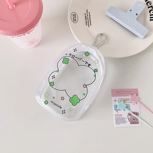 Detail view of transparent PVC pouch with green clover patterns and silver metal buckle