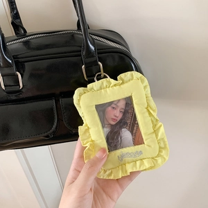 Pale yellow ruffled 3-inch photo card holder pendant with silver embroidery on a bag