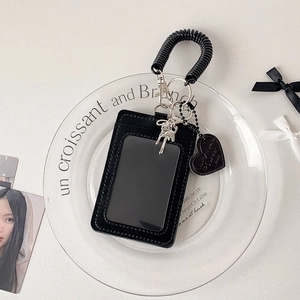 Detail of black elastic wrist strap with cat charm and heart tag for the card holder