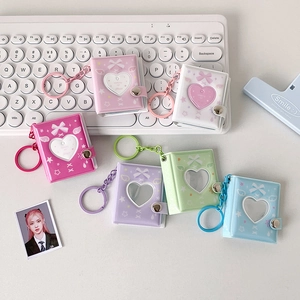 Macro detail of six pastel mini photo album keychains with heart cutouts and bow design
