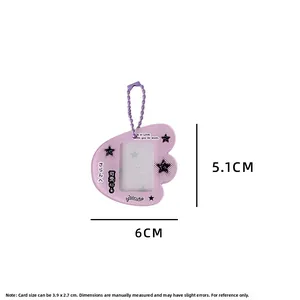 Close-up of a purple glitter wing-shaped photocard holder with star accents and ball chain
