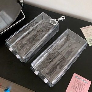 Detailansicht der transparenten PVC-Puppentasche mit weißen Knöpfen und praktischem Haken