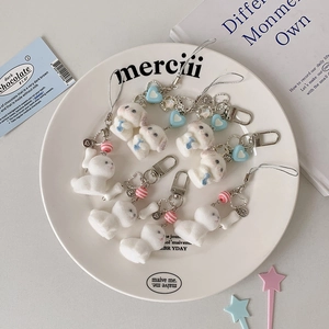 Porte-clés chiot en peluche blanche avec nœuds bleus et clips métalliques pour sacs
