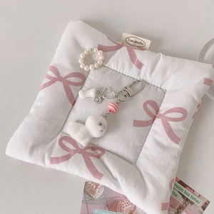 Détail du porte-clés chien en peluche blanc avec anneau perlé et breloque en forme de cœur