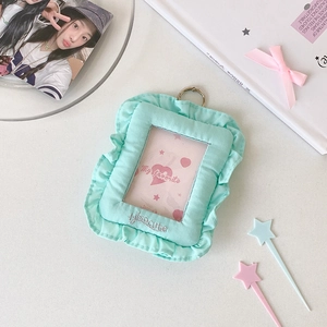 Detail showing mint green fabric photocard holder with ruffled edges and gold metal ring