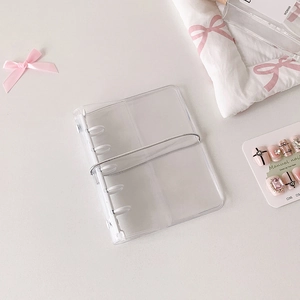Macro view of clear PVC binder with silver elastic strap for nail art display and storage