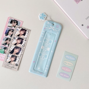 Close-up of light blue photocard holder with cute bow prints and silver bead chain