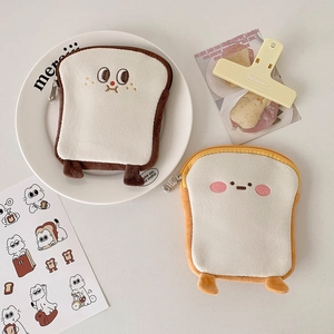 Detailansicht von Plüschtaschen in Toastform mit Stickerei und Metallreißverschluss