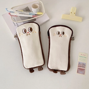 Detail eines Plüsch-Toast-Mäppchens mit Stickerei und Metallreißverschluss am Tisch