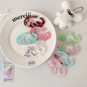 Gros plan de mousquetons en acrylique colorés en forme d'ailes avec motifs mignons