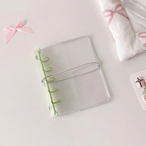 Detail of transparent PVC binder with 6-hole light green rings and silver elastic strap